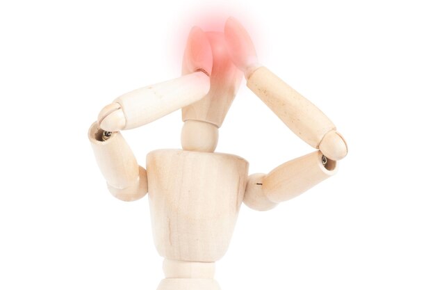 Photo headache on a wooden mannequin representation of migraine pain articulated figure grabs his head