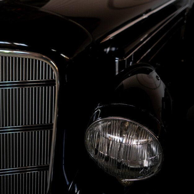 The headlight of an antique, rarity, vintage black car.