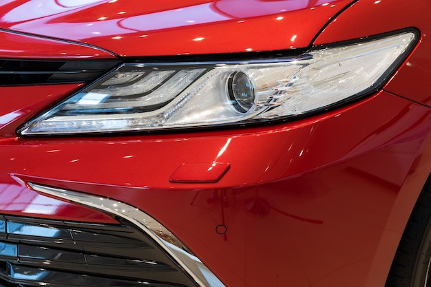 Headlight of a red stylish car close up