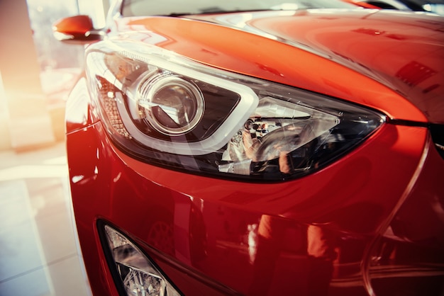 Headlights and hood of sport red car.