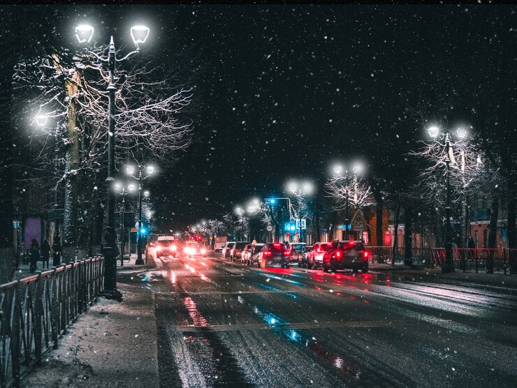 Фары в ночном зимнем городском потоке.