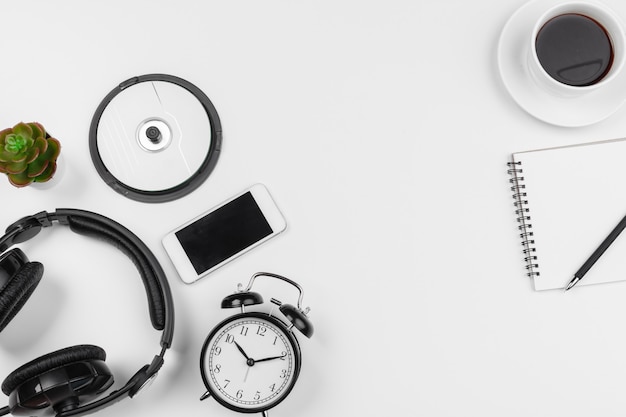 Headphones and alarm clock isolated on white 