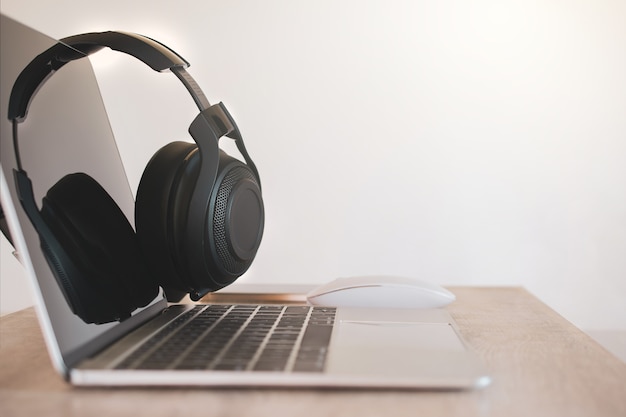 Headphones black, smartphone and laptop on Work Desk.