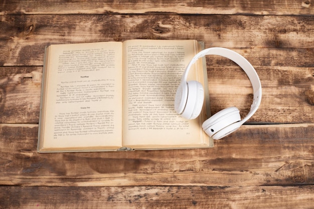 headphones and book on wooden background