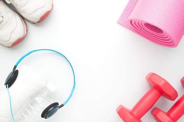 Headphones, bottle of water and sport equipments isolated on white background