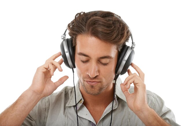 헤드폰은 흰색 배경의 오디오 구독 스트리밍 멀티미디어 또는 디지털 라디오를 위해 스튜디오에 있는 사람이나 음악을 진정시킵니다. 평화로운 팟캐스트 청각 소리를 듣거나 노래를 위해 휴식을 취하는 모델의 얼굴