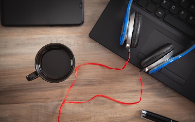 Headphones coffee computer keyboard on the wooden desk