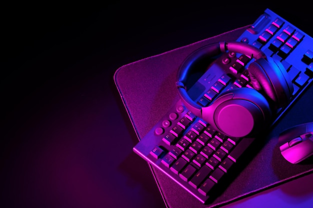 Photo headphones computer mouse and keyboard on black background