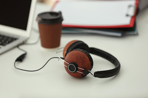 Headphones and cup of coffee on office table