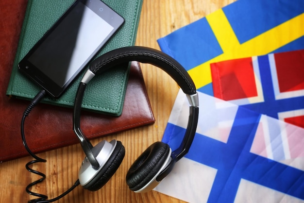 Headphones and flag on a wooden background concept course language