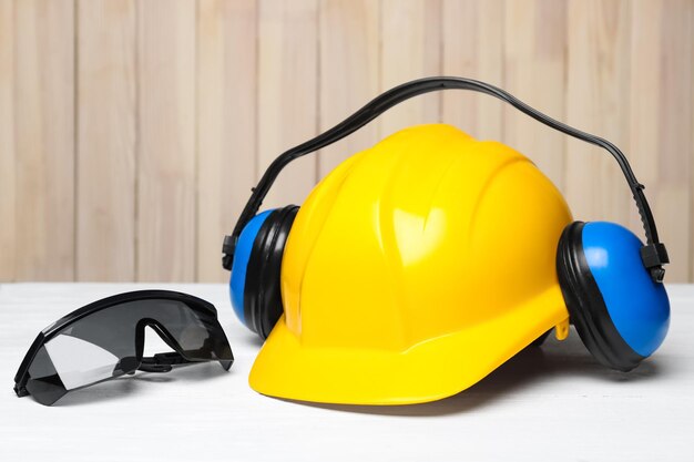 Headphones hard hat and goggles on table Hearing protection equipment