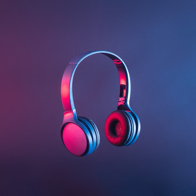 Headphones or headset in neon light to listen to trending or other contemporary disco music