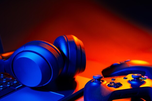 Headphones joystick and computer keyboard on black table