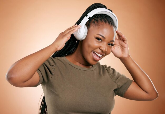 Headphones music and black woman in portrait isolated on studio background for mental health energy and podcast happy african person listening to audio technology with smile on face for sound