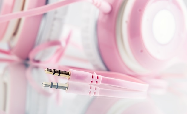 Headphones. Pink Headphones with jack connector - mirror reflection.