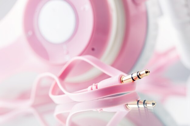 Headphones. Pink Headphones with jack connector - mirror reflection.