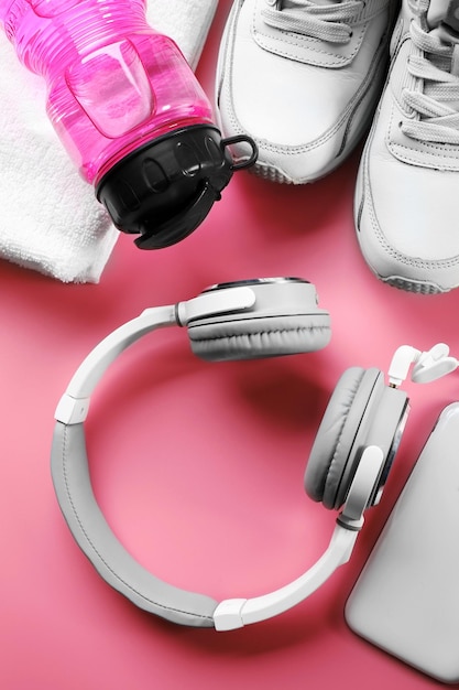 ピンクの背景にヘッドフォンとスポーツ用品