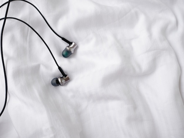 Headphones on white bed. 