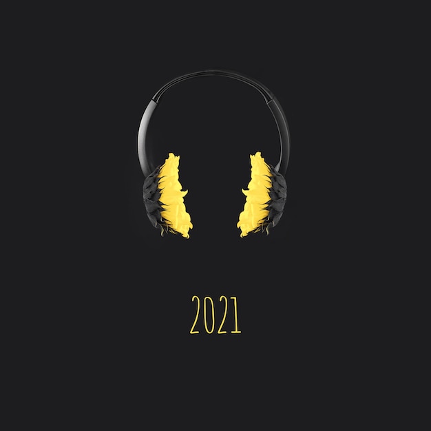 Headphones with yellow sunflowers hover in the air on a gray background, color concept of the year 2021