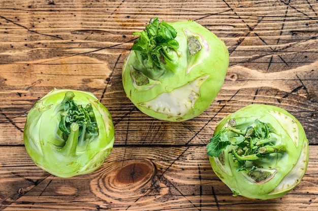 Heads of fresh ripe white cabbage kohlrabi. Wooden background. Top view.