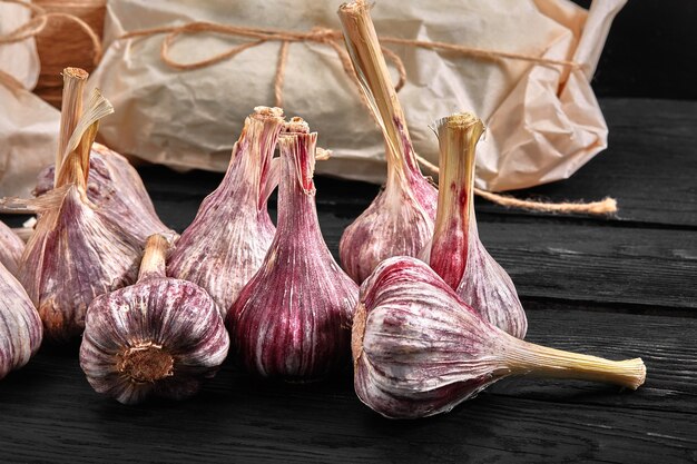 The heads of red garlic on a dark surface, ecological packaging. Beautifully laid out heads of garlic, closeup.