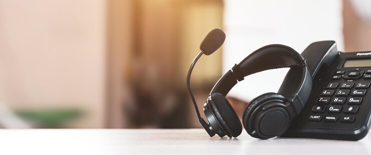 Foto headset en telefoon op bureau.