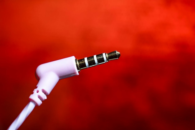 Headset plug closeup on a red background macro photo