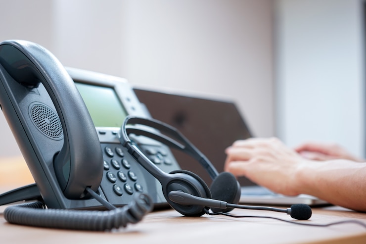 Photo headset with blurred of call center employee hand working in operation room 