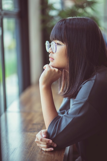 Headshot of asian teenager sitting at living room table