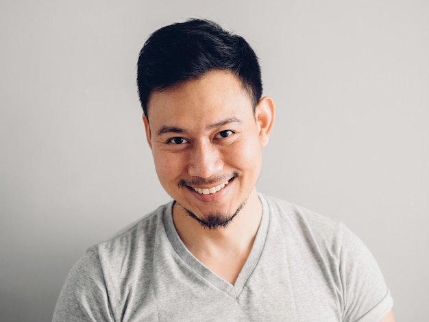 Headshot photo of Asian man with laugh face. on grey background.