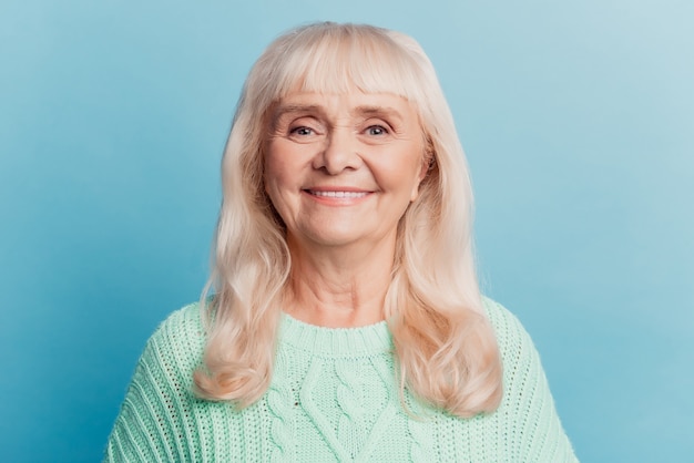 Headshot photo of happy senior woman isolated on blue background