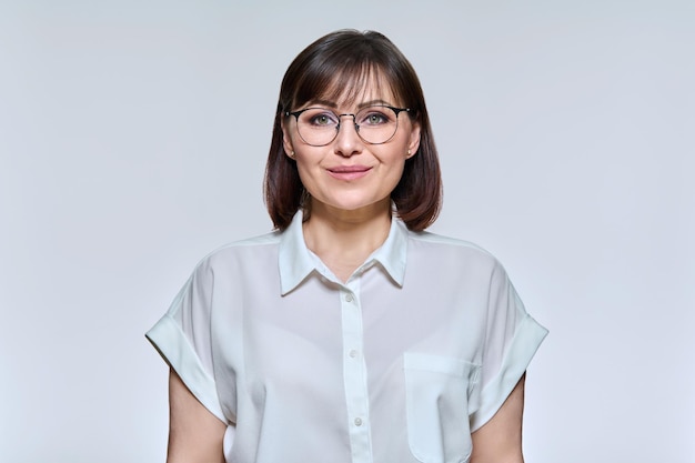 Headshot portrait of smiling middle aged woman looking at camera