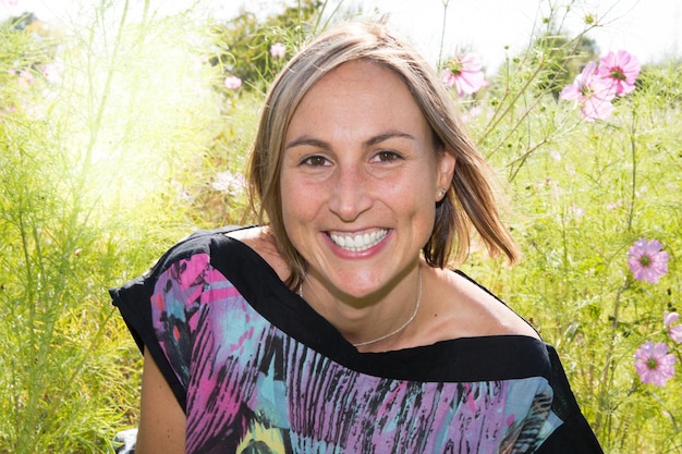 Foto headshot portret van een vroege jaren '30 casual mooie blonde vrouw in het park op een zonnige zomerdag