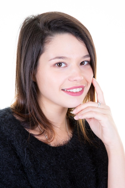 Headshot portret van gelukkig meisje met de hand op de kin glimlachend camera kijken op witte achtergrond