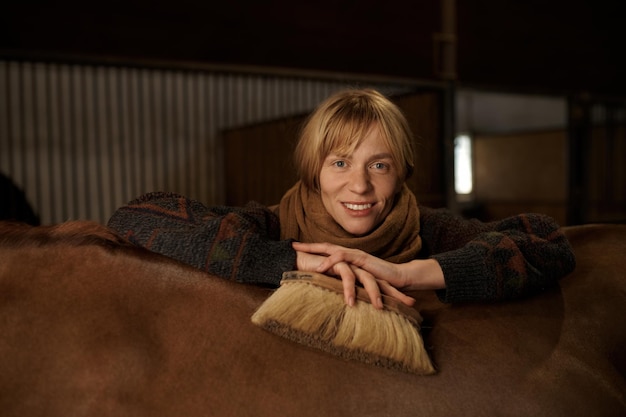 Headshot portret van jonge lachende amazone achter paard van haar goed verzorgde rasechte hengst