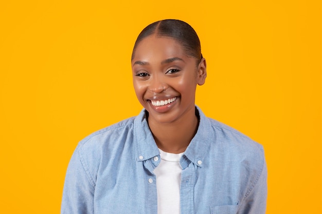 Headshot of pretty african american woman in denim shirt studio