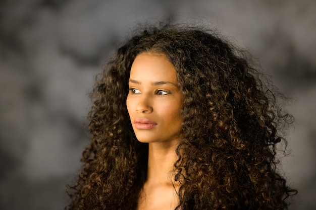 Headshot van een mooie doordachte zwarte meid met lang krullend haar