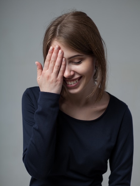 Headshot van schattige aantrekkelijke jonge Europese vrouwen die open mond met de hand en de ogen sluiten