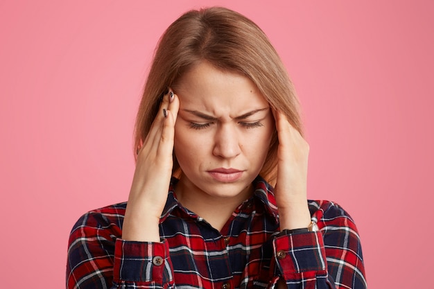 Headshot van stressvolle vrouw houdt handen op tempels