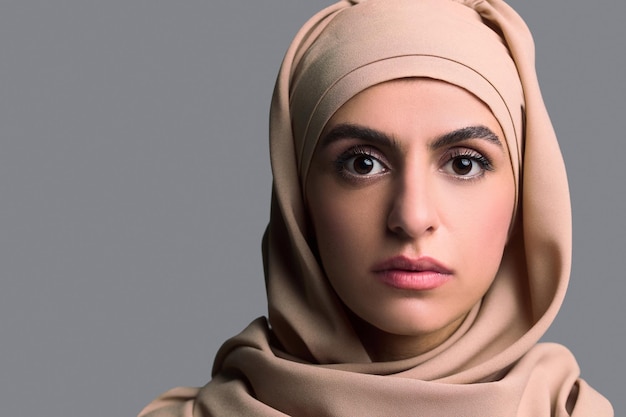 Foto colpo alla testa di una giovane donna in hijab beige