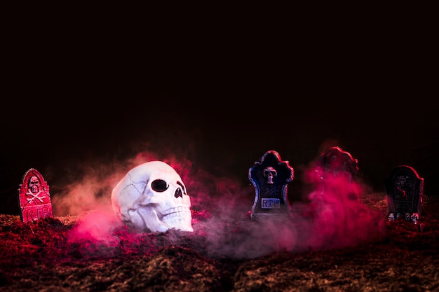 Photo headstones and skull between pink fog on ground