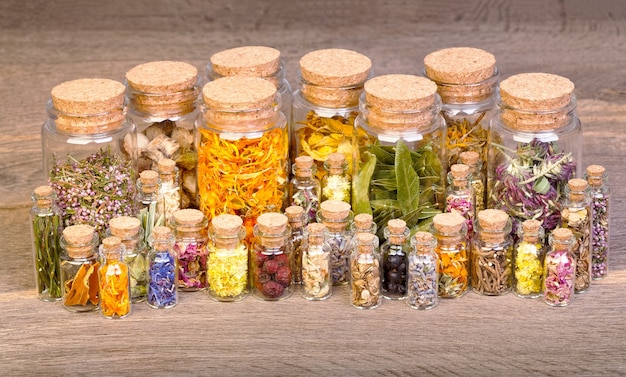 Healing herbs in bottles for herbal medicine on old wooden table