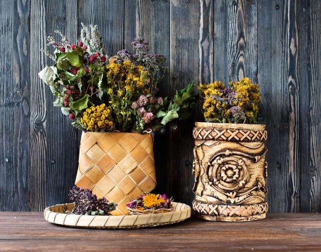 Healing herbsÃÂ  and flowers in birch bark boxes on a wooden background. Herbal medicine