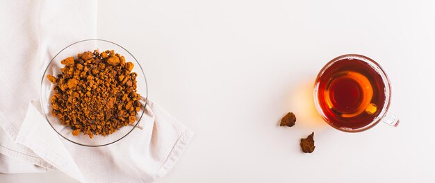 Photo healing tea from wild birch chaga mushroom in a cup on the table top view web banner