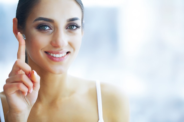 Health and Beauty. Beautiful Young Girl with Contact Lenses. Woman Holds Green Contact Lens on Her Finger. Healthy View