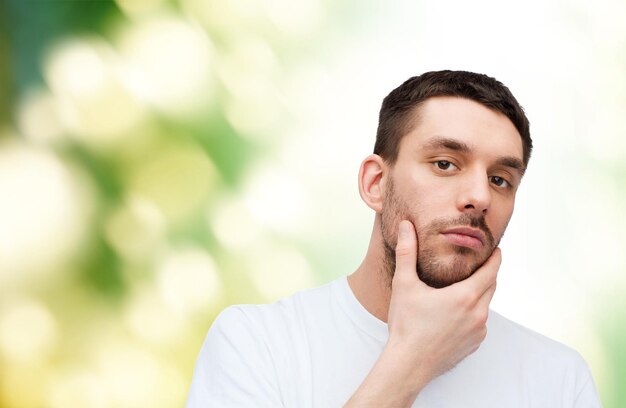 health and beauty concept - beautiful calm man touching his face