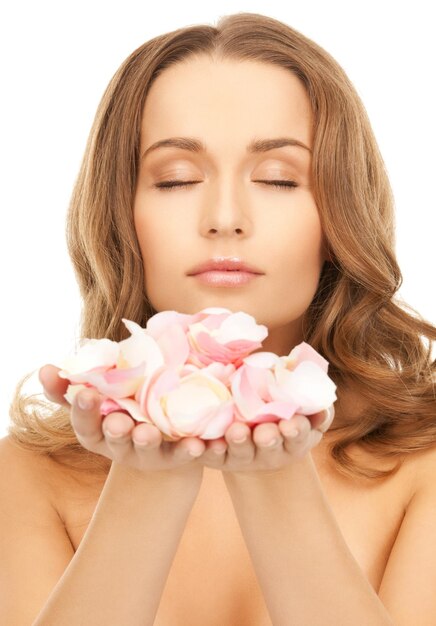 Foto concetto di salute e bellezza - bella donna con petali di rosa