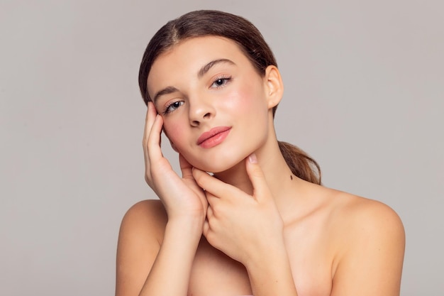 health and beauty concept beautiful young woman with clean fresh skin touch own face facial treatment cosmetology beauty and spa