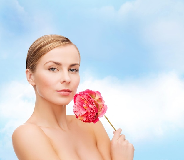 健康と美容のコンセプト-ピンクの牡丹の花を持つ素敵な女性