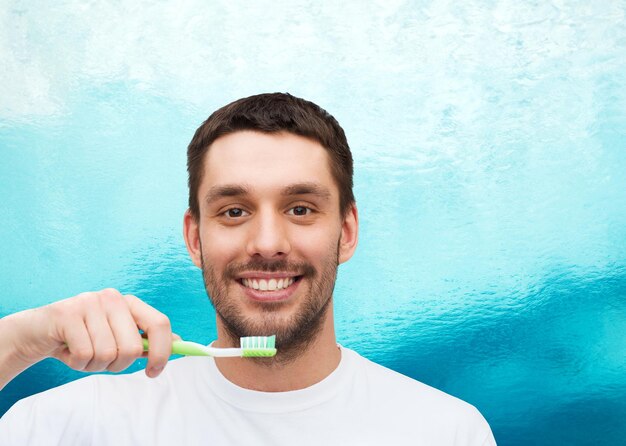 health and beauty concept - smiling young man with toothbrush